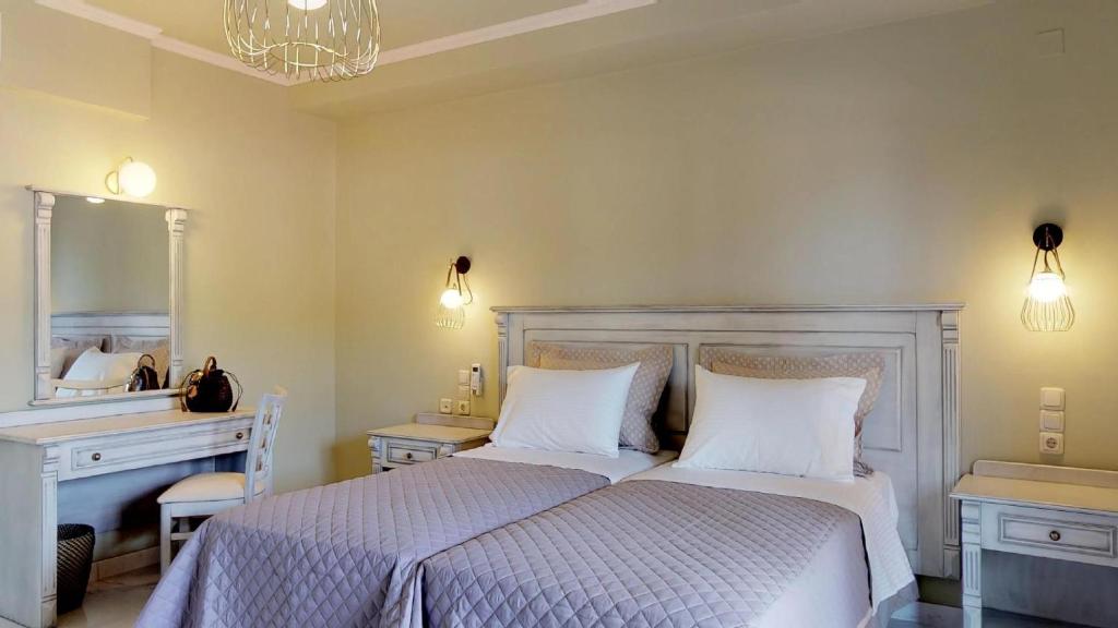a bedroom with two beds and a vanity and a mirror at Parga Inn Suites in Parga