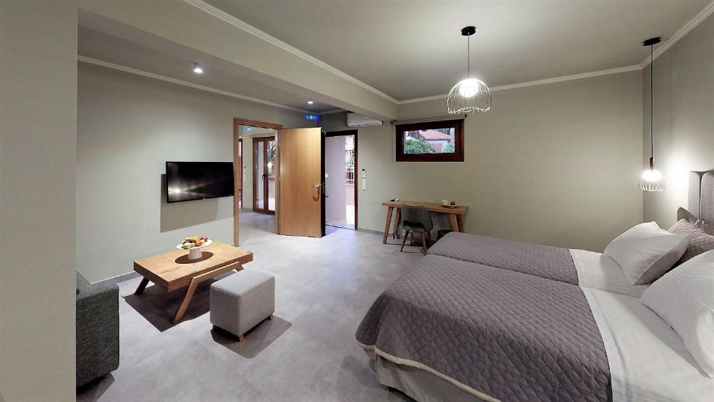 a bedroom with a bed and a table and a television at Parga Inn Suites in Parga