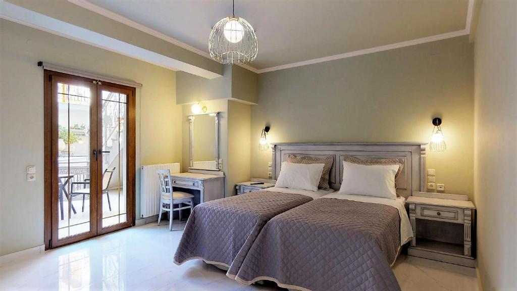 a bedroom with a bed and a table and a window at Parga Inn Suites in Parga