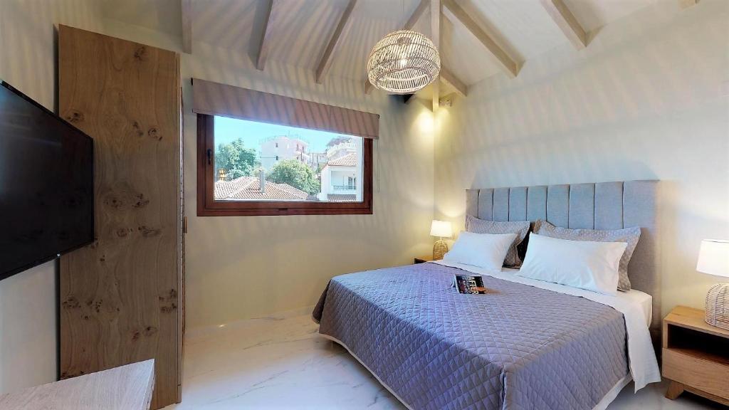 a bedroom with a bed and a window and a television at Parga Inn Suites in Parga