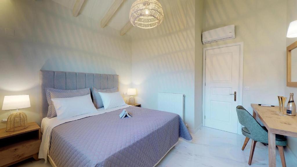 a bedroom with a bed and a desk and a table at Parga Inn Suites in Parga