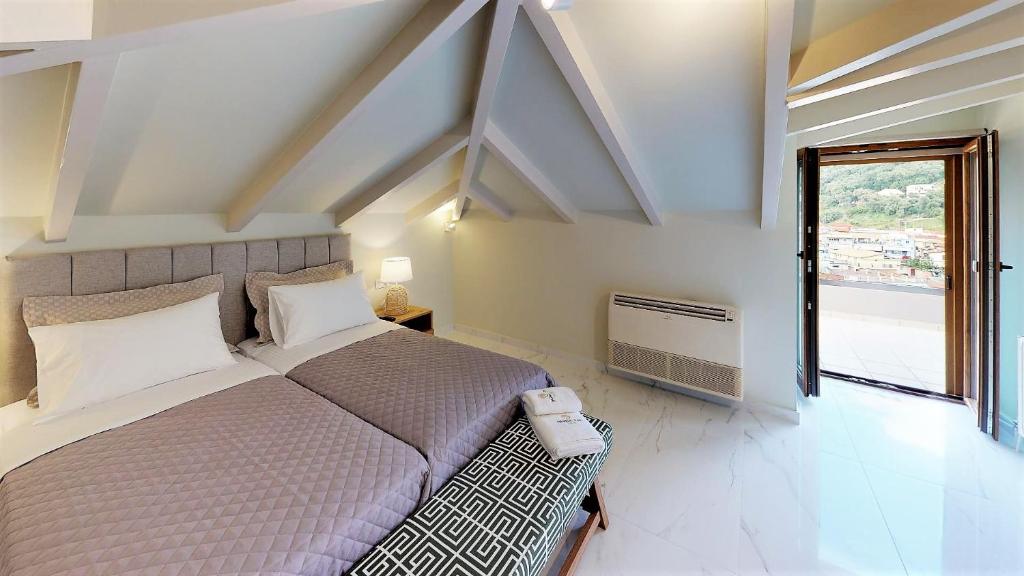 a bedroom with a large bed and a window at Parga Inn Suites in Parga