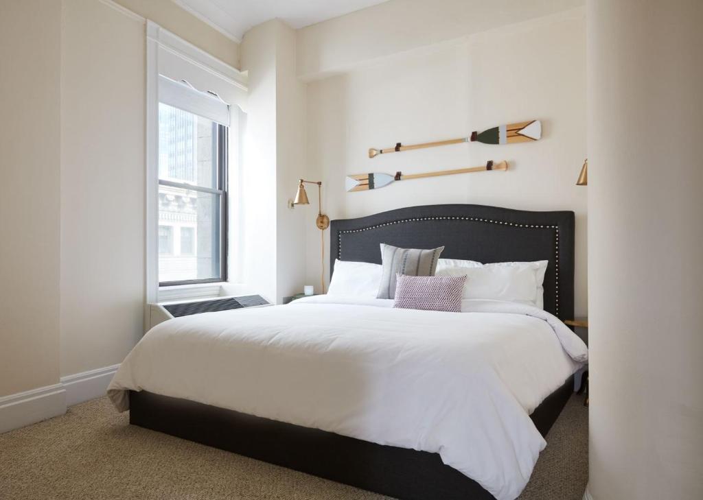 a bedroom with a large bed and a window at Evonify Stays - Theatre District Apartments in Boston