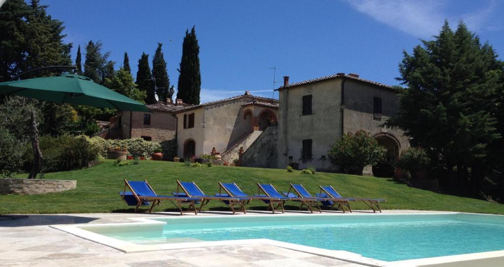 a group of blue lounge chairs next to a house at Casale Le Borghe - Montalcino,Toscana in San Giovanni dʼAsso