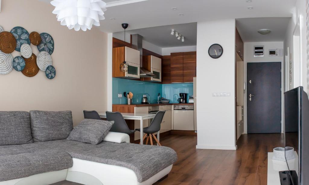 a living room and kitchen with a couch and a table at Center Rev Apartment in Győr