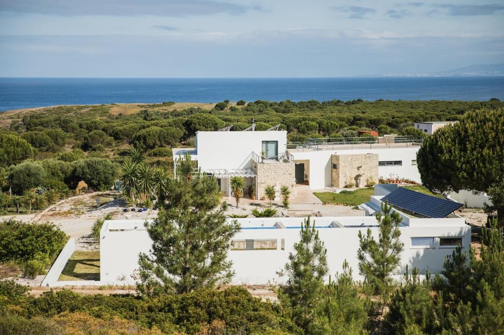 an aerial view of a white house with the ocean in the background at Entre Mar e Mar in Aldeia do Meco