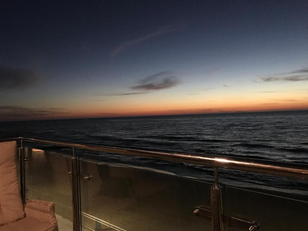 a view of the ocean at sunset from a cruise ship at Apartament Promenada in Sarbinowo