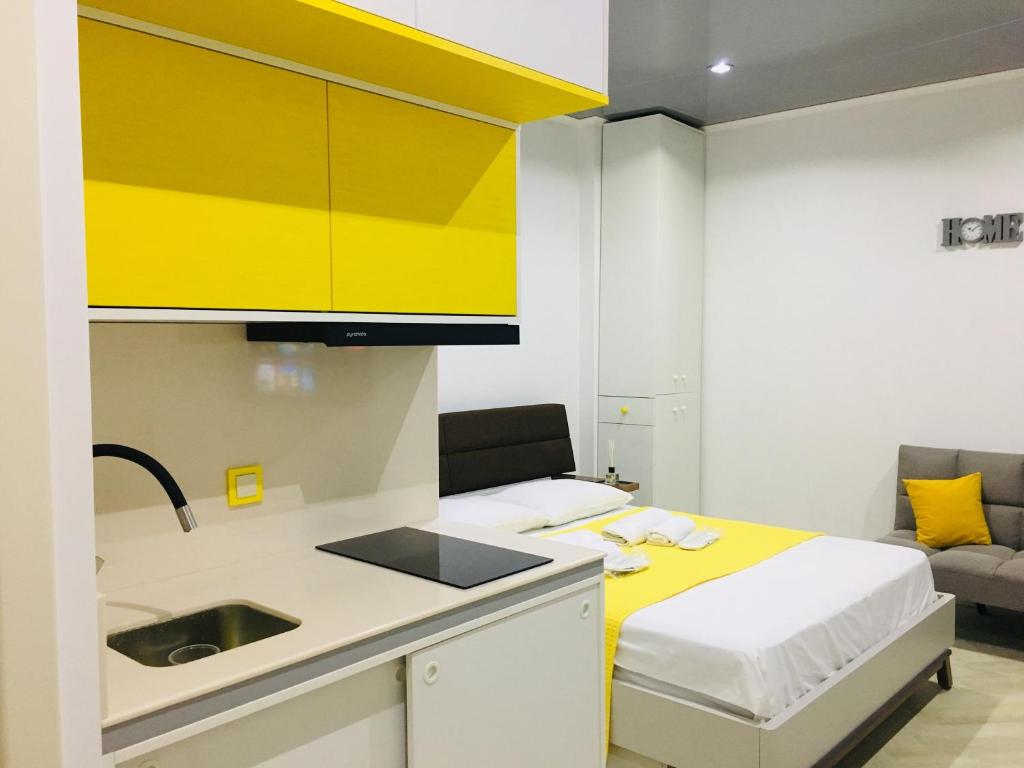 - une cuisine avec un évier et des armoires jaunes dans la chambre dans l'établissement Yellow room with sea view, à Makhinjauri