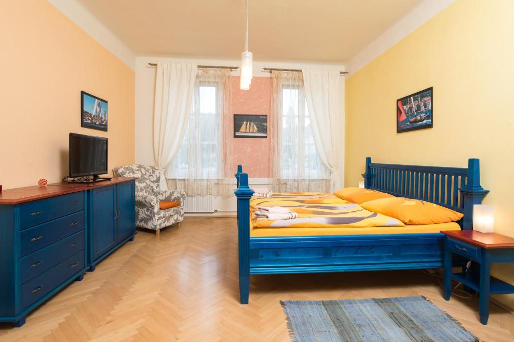 a bedroom with a blue bed and a tv at Pension Ibérica in Brno