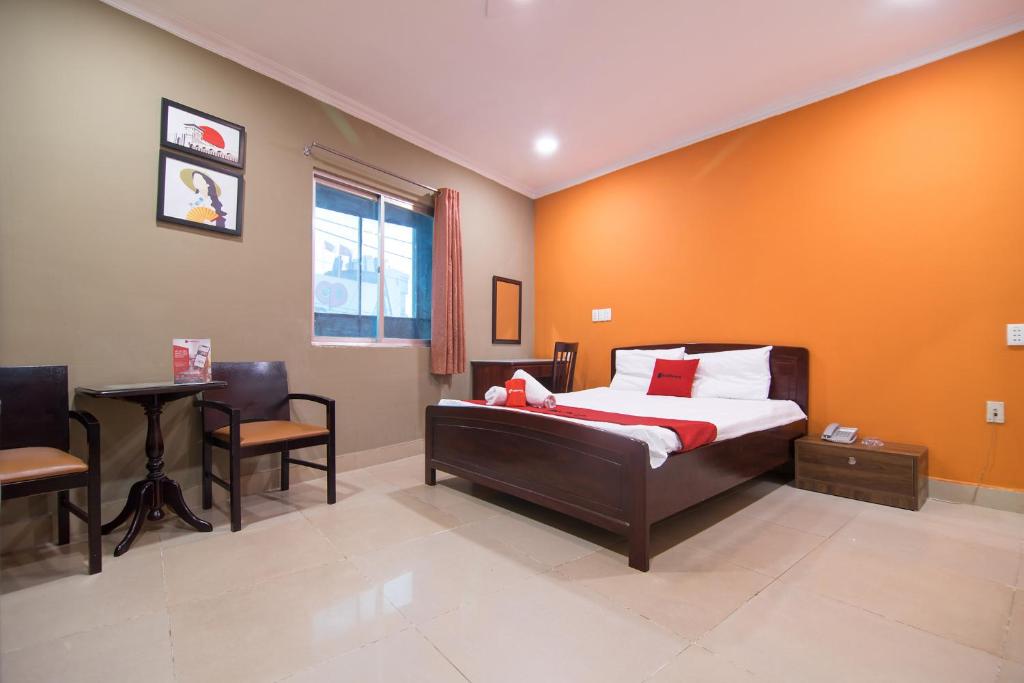 1 dormitorio con 1 cama, mesa y sillas en Van Giao Hotel, en Ho Chi Minh