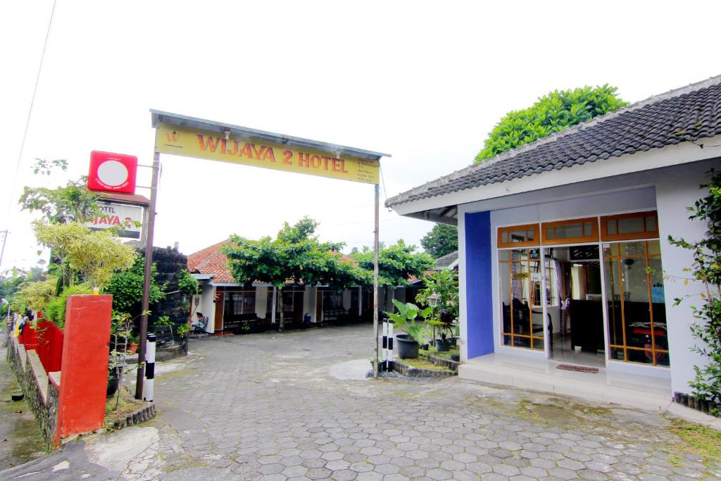 a building with a sign in front of a street at Hotel Wijaya 2 Kaliurang in Yogyakarta