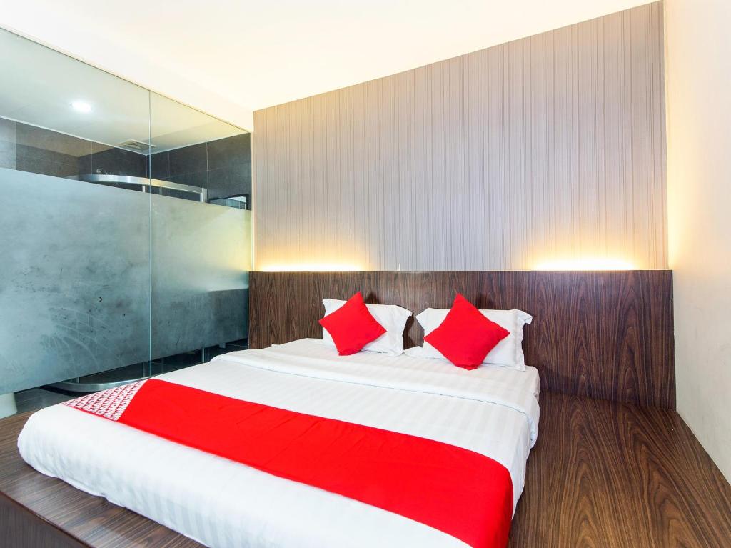 a bedroom with a large bed with red pillows at Super OYO 340 Comfort Hotel in Kampong Batu Belah