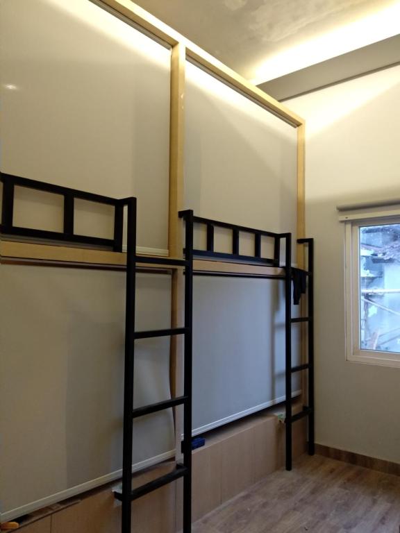 a room with two bunk beds and a whiteboard at XOXO Kuta Legian Hostel in Legian