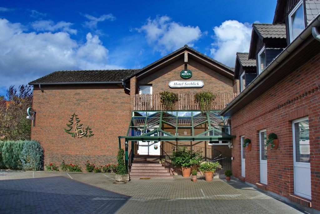 a brick building with a clock on the side of it at Hotel Seeblick garni in Gartow