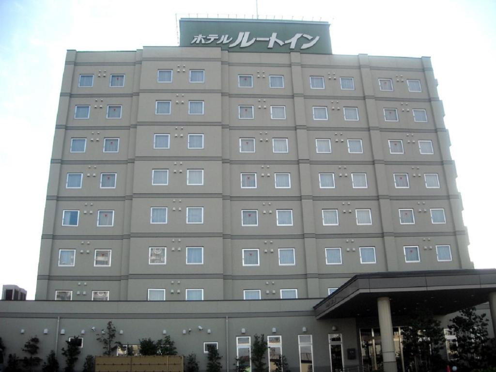 un edificio con un cartel encima en Hotel Route-Inn Honjo Ekiminami, en Honjo