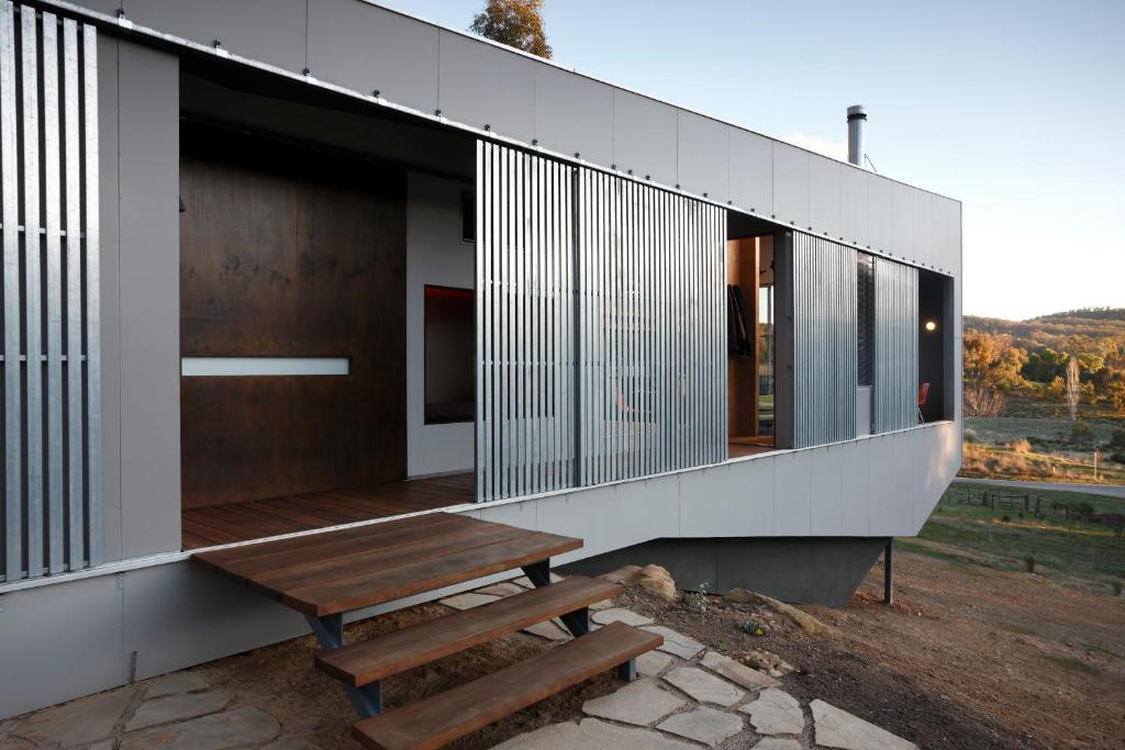 a house with a wooden bench on the side of it at Riversdale Retreat in Chewton