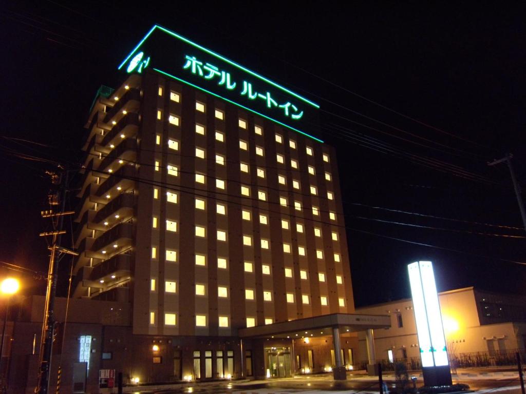 鶴岡市にあるホテルルートイン鶴岡駅前の夜間の看板のある建物