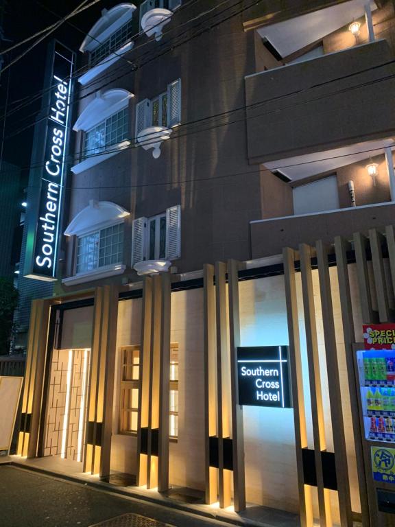 un edificio con un cartel en el costado en City Hotel Southern Cross en Tokio