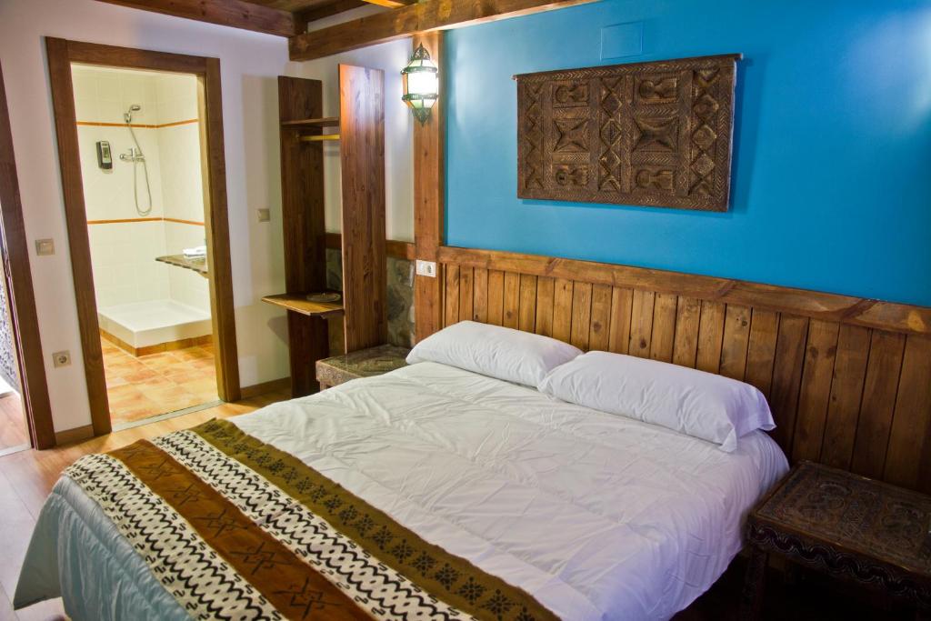 a bedroom with a large bed with a blue wall at Hotel Plaza in Cuenca