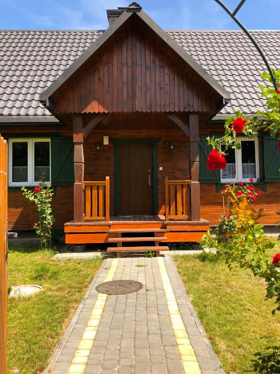 a wooden cabin with a bench in front of it at Ostoja Kaczórki in Kaczórki