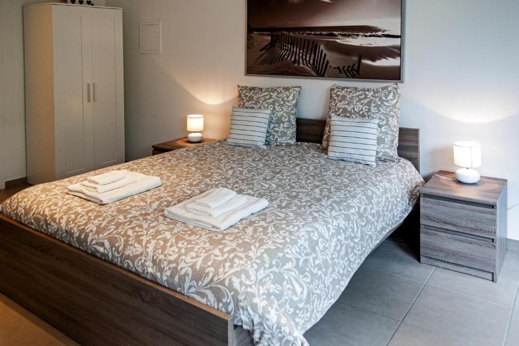 ein Schlafzimmer mit einem Bett mit zwei Handtüchern darauf in der Unterkunft studio du botanique in Bayeux