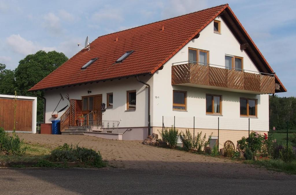 a large white house with a red roof at Brachfeld zehneins Ferienwohnung in Sulz am Neckar