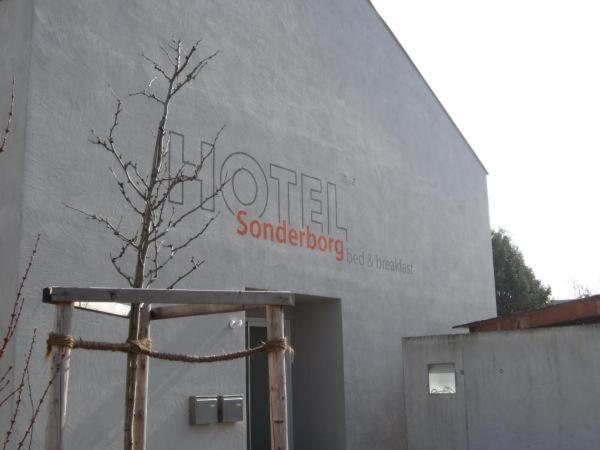 a building with a sign on the side of it at Hotel Sonderborg in Schrobenhausen