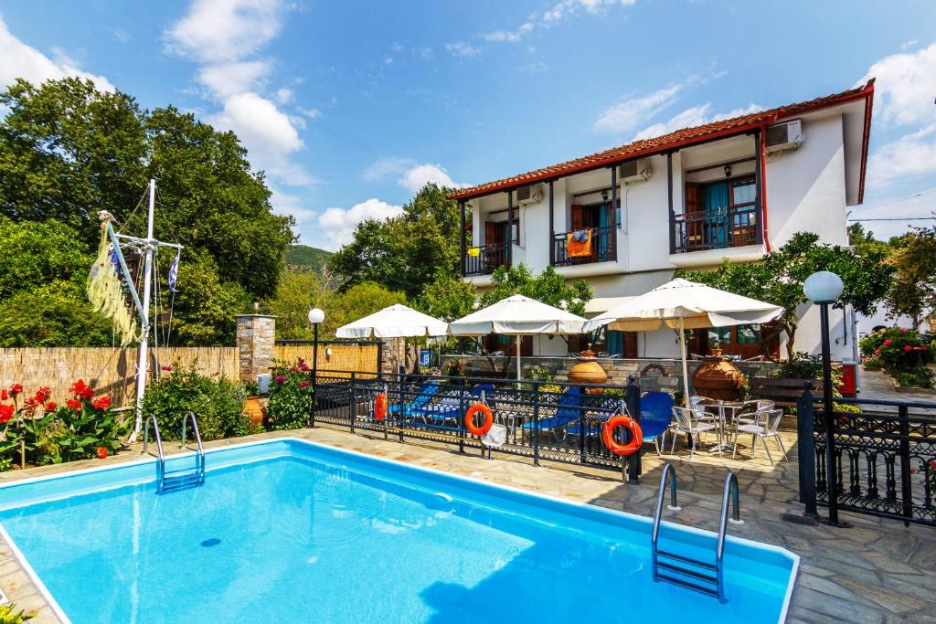 a swimming pool in front of a building with a restaurant at Charoula in Platanias