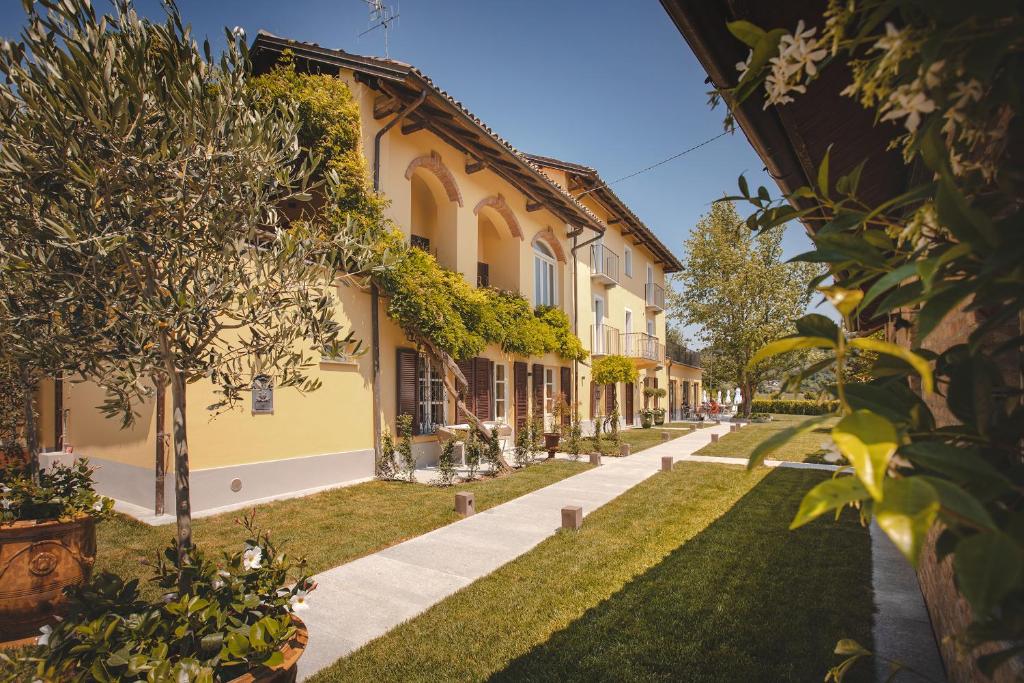 eine Reihe von Häusern mit Bäumen und Gras in der Unterkunft Residenza San Vito in Calamandrana
