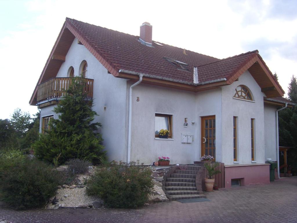 een wit huis met een trap ervoor bij Ferienwohnung Ina in Rust