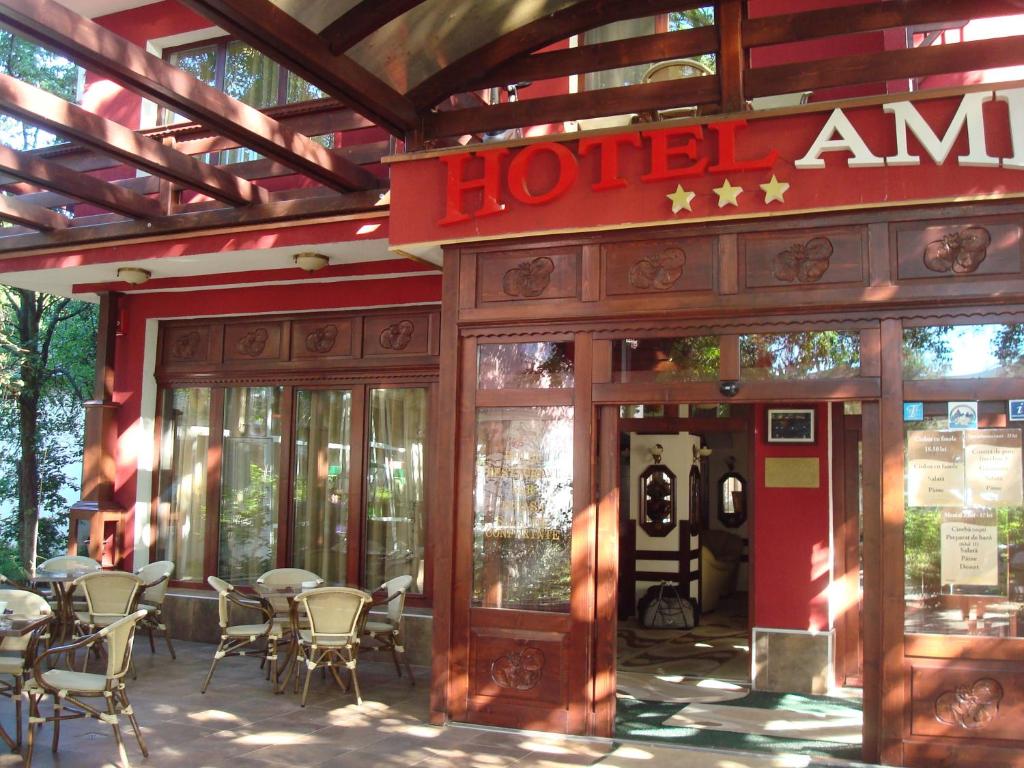Hotel Ami في بايلي فيليكس: فندق به طاولات وكراسي خارج المبنى