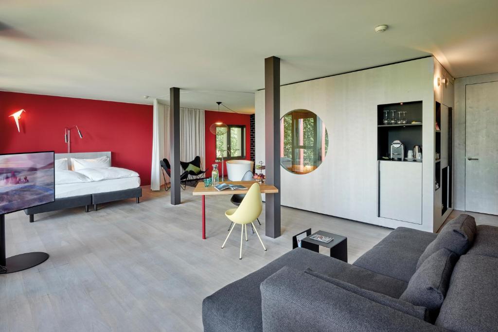 a living room with a couch and a bed at Sorell Hotel Rigiblick - Studios & Spa Suites in Zürich