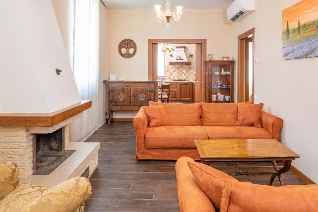 sala de estar con sofá y chimenea en Borgo Apartment, en Bardolino