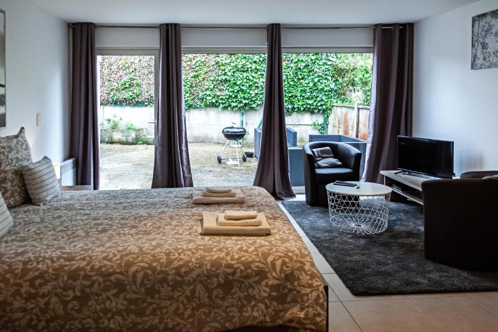 - une chambre avec un lit et 2 serviettes dans l'établissement studio du botanique, à Bayeux