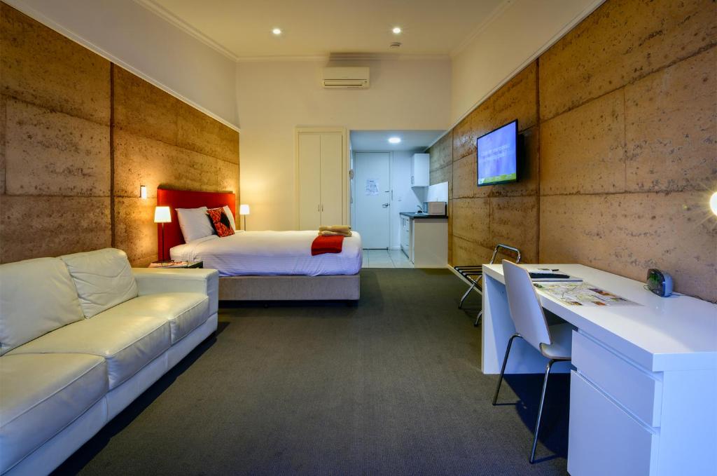 a hotel room with a bed and a couch at Crossroads Ecomotel in Port Augusta