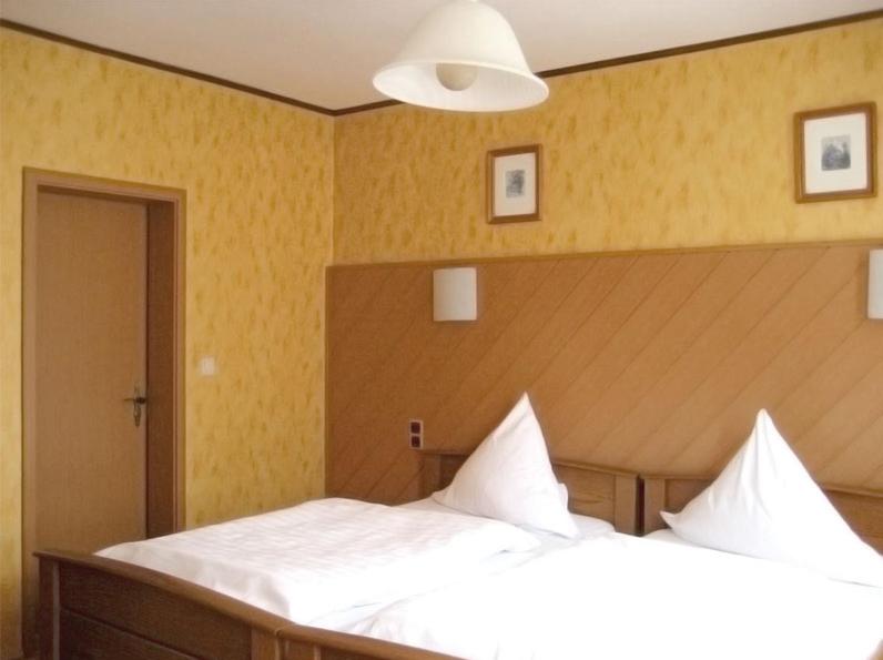 a bedroom with two white beds and a light at Hotel Alt Wassenberg in Wassenberg