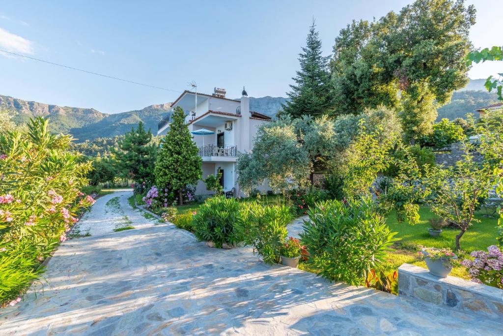a house with a garden with trees and bushes at Studios Vasilia in Skala Potamias