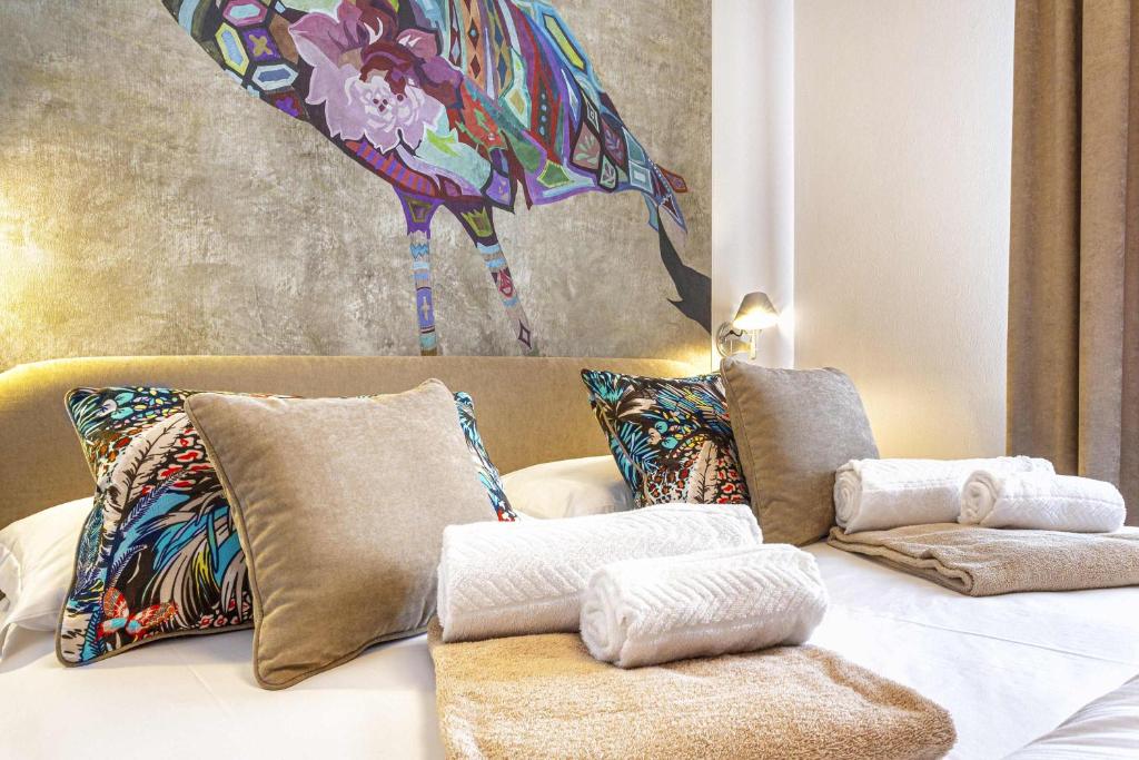 Pokój z łóżkiem z poduszkami i obrazem pawia w obiekcie Costa Rica Bibione Aparthotel w Bibione