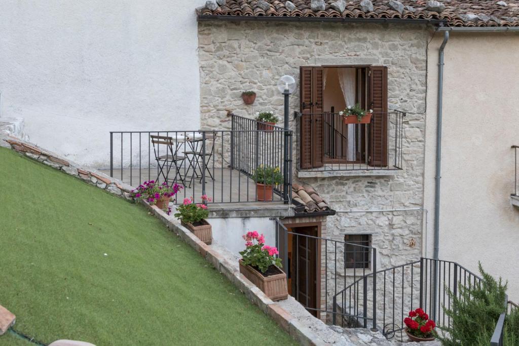 ein Haus mit einem Balkon mit Topfpflanzen darauf in der Unterkunft La casa in pietra in Villa Santa Maria