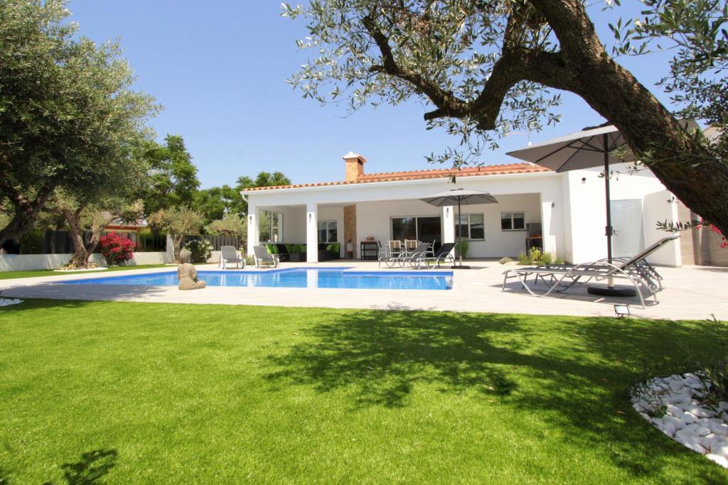 a villa with a swimming pool and a yard at LEON INMO Villa Magna - 12262 in Empuriabrava
