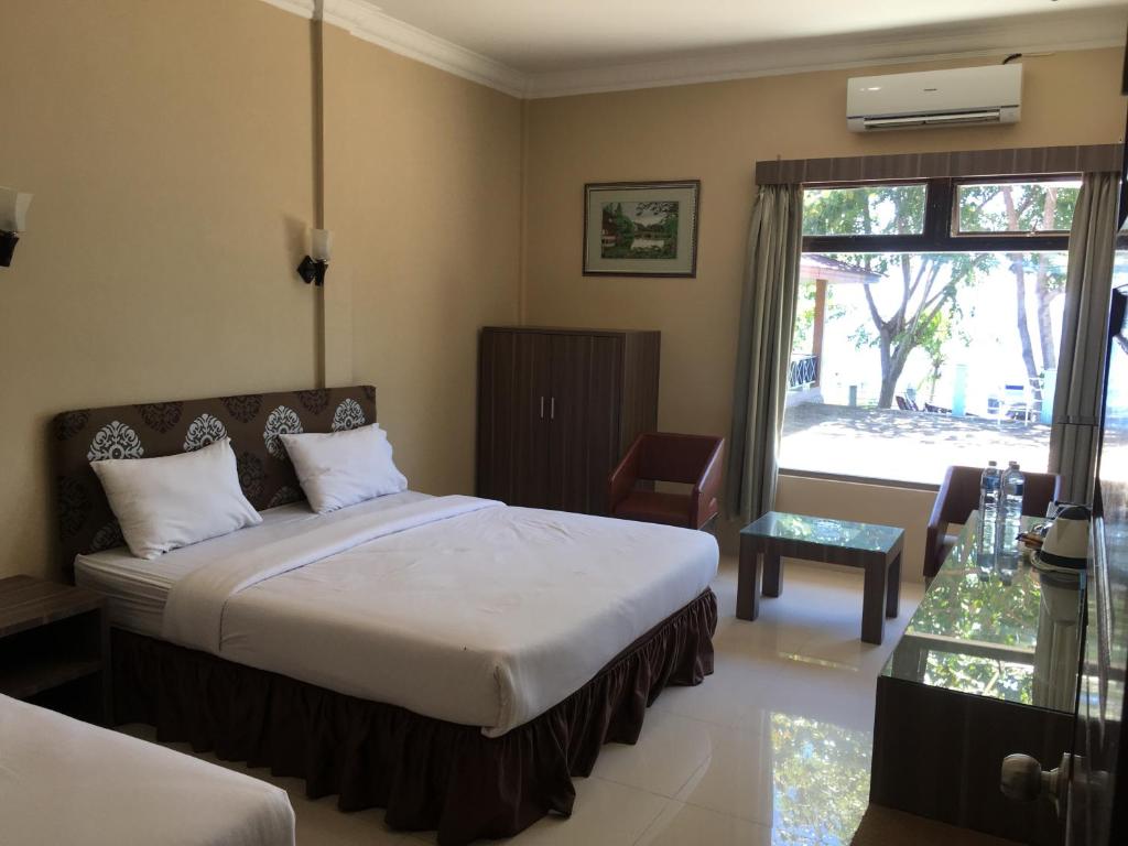 a bedroom with a bed and a large window at Anoi Itam Resort in Sabong