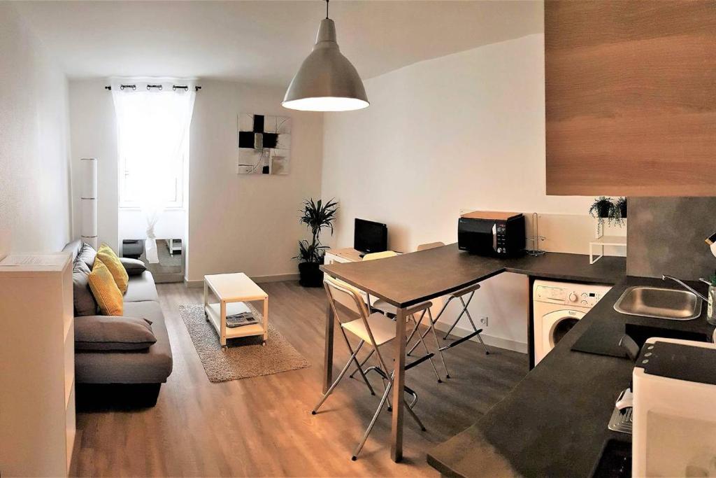 - une cuisine et un salon avec une table dans la chambre dans l'établissement Très bel appartement Centre Vitré, à Vitré