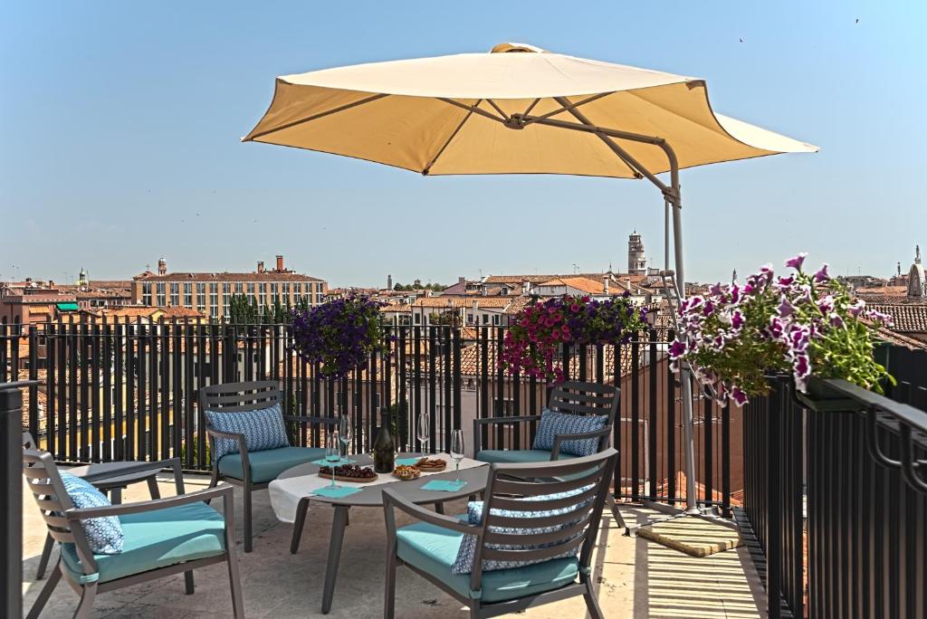 un tavolo e sedie con ombrellone su un balcone di Ca' Venar a Venezia