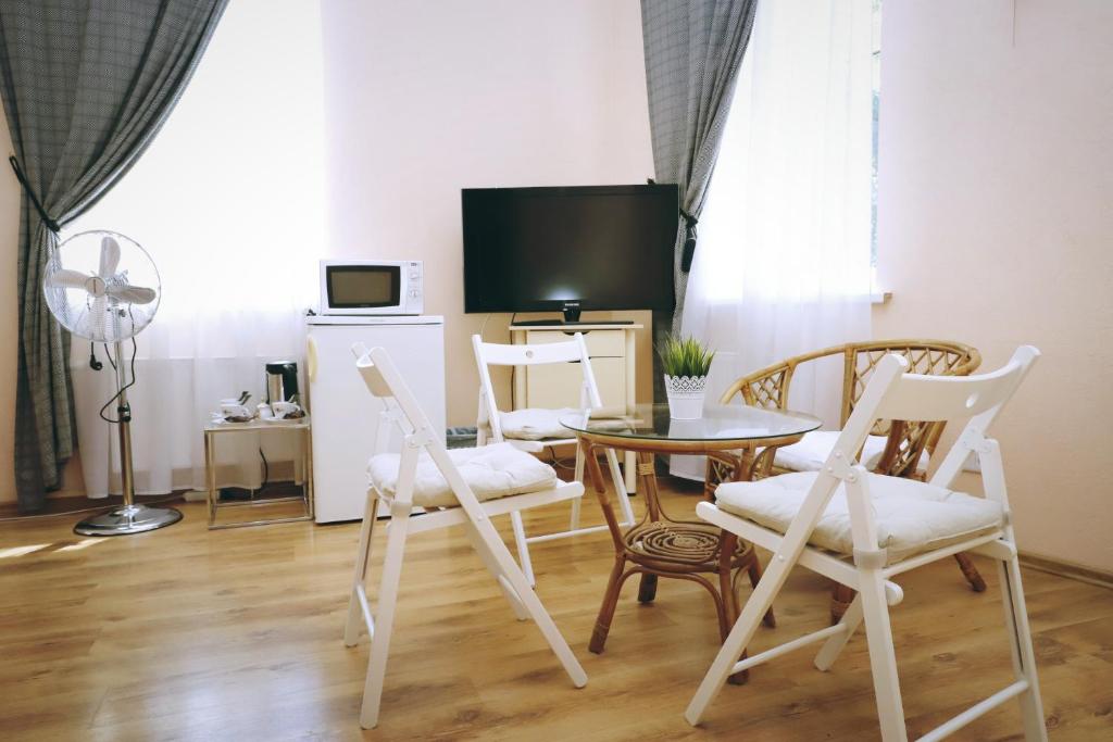 a living room with a table and chairs and a tv at Apartamenti DVINSKA in Daugavpils