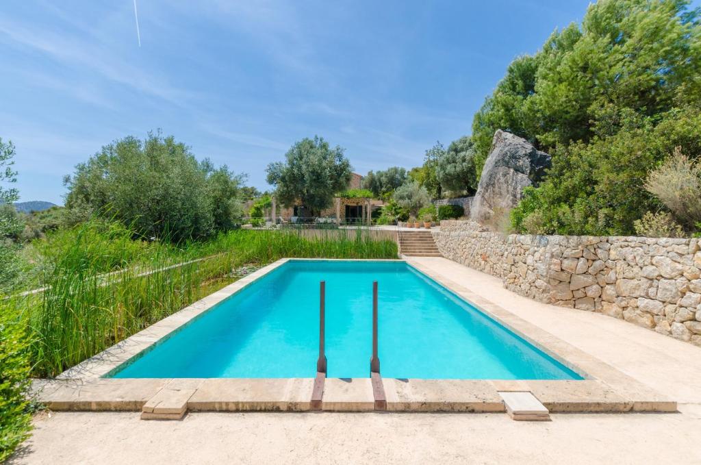 uma piscina numa villa com uma parede de pedra em Puig De Garrafa 6 em Andratx
