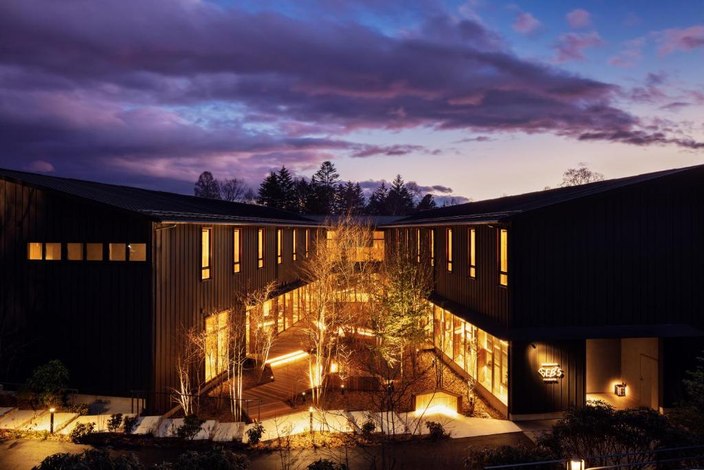 un grand bâtiment avec des lumières devant lui dans l'établissement Hoshino Resorts BEB5 Karuizawa, à Karuizawa