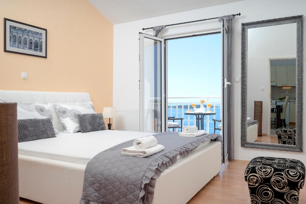 1 dormitorio con 1 cama y vistas a un balcón en Apartments Roso - Hvar, en Hvar