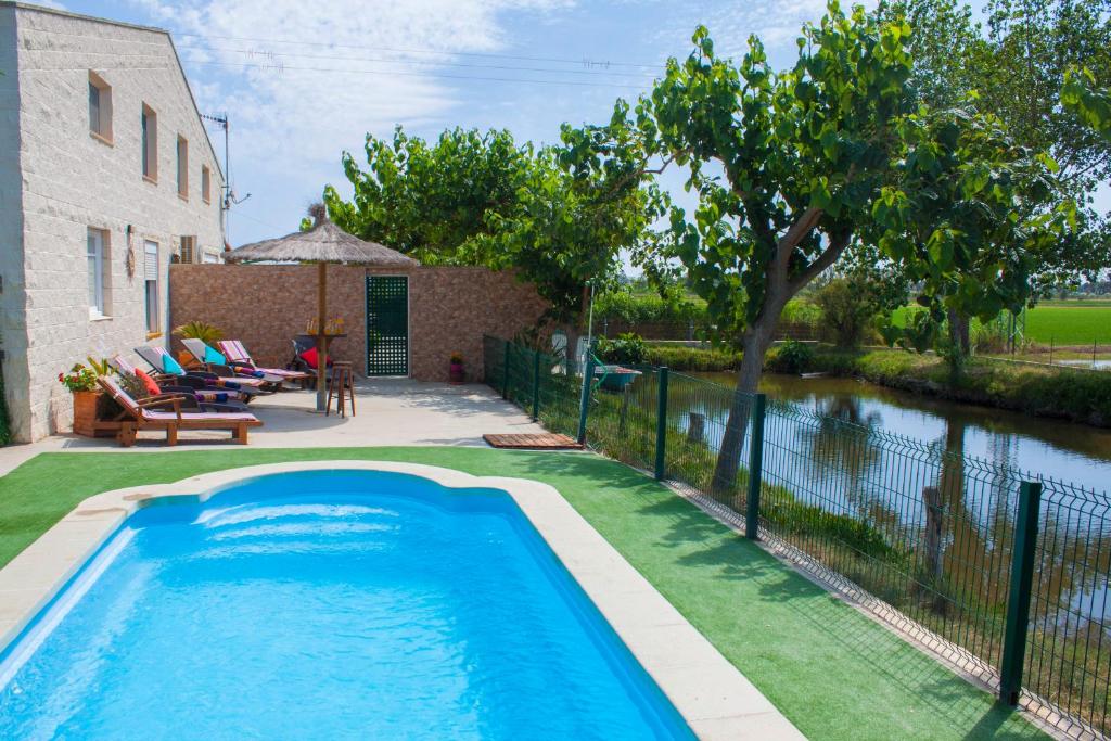 a swimming pool in a yard next to a house at Paradise Ebro 2 in Deltebre