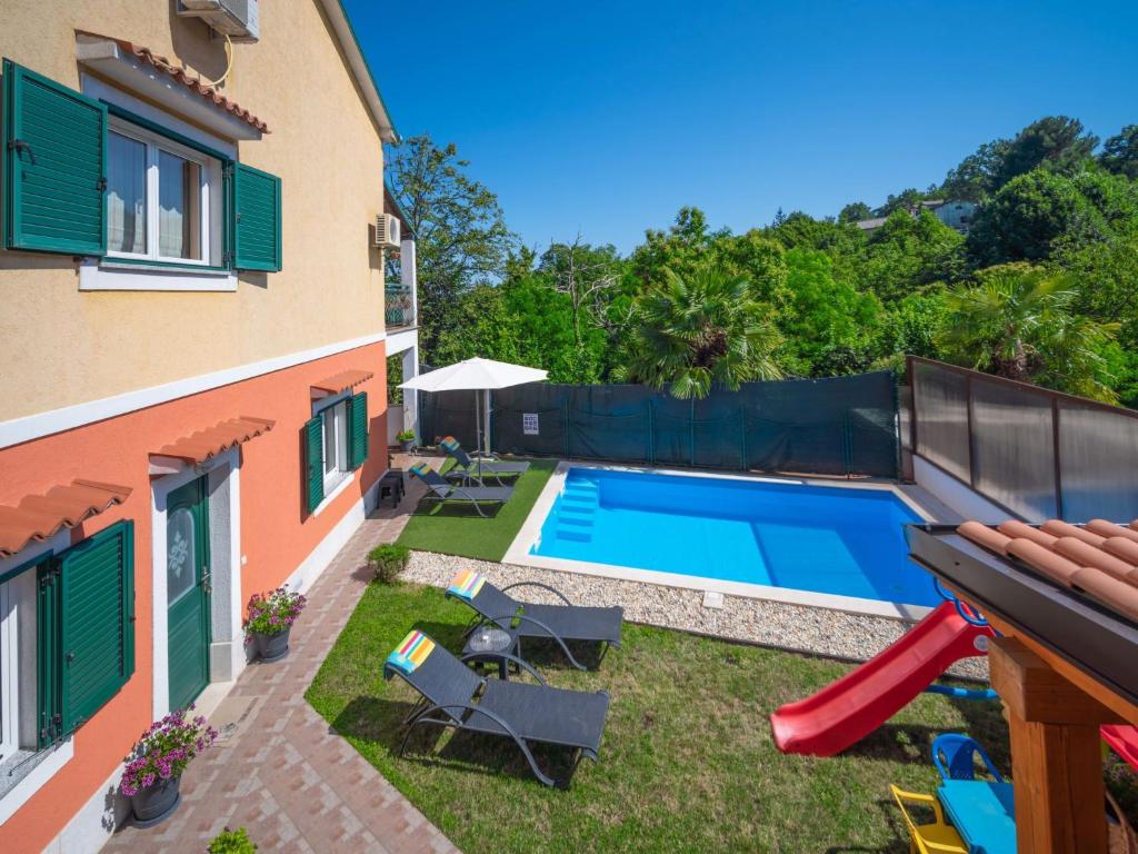 a backyard with a swimming pool and a house at Apartment Sandra by Interhome in Matulji