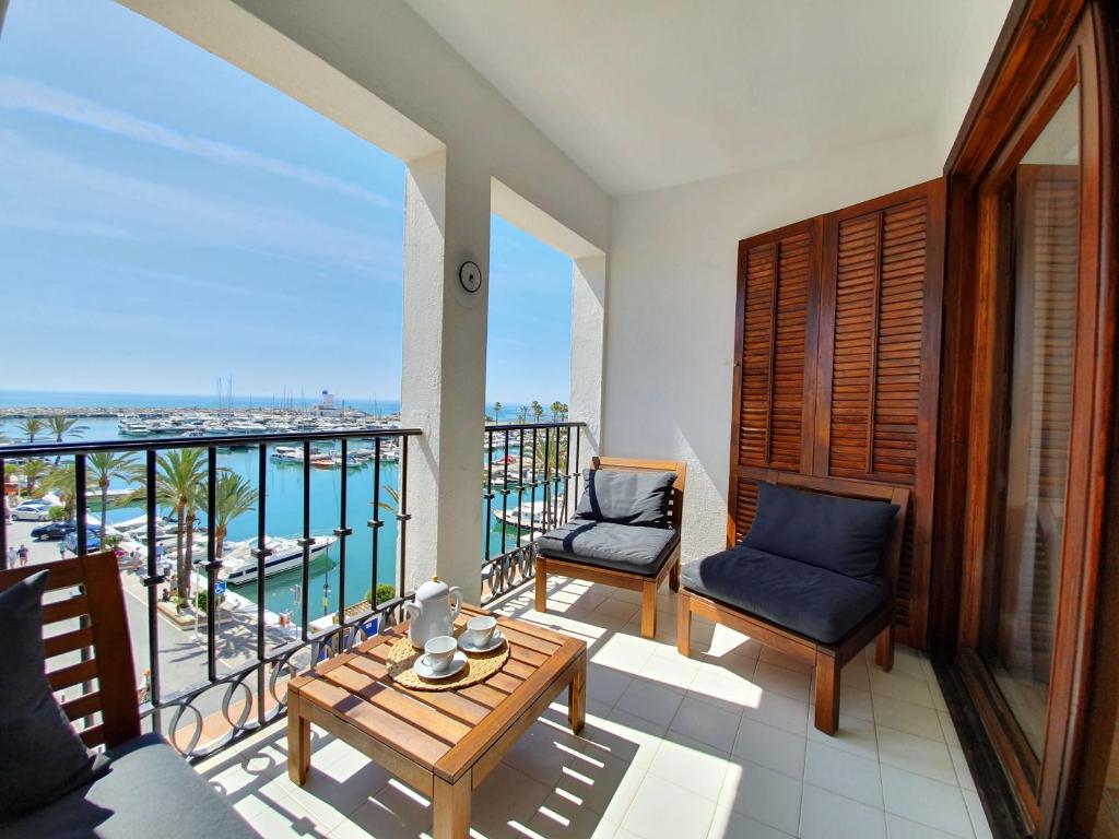 ein Balkon mit Tisch und Stühlen und dem Meer in der Unterkunft Villa La Palmeraie Puerto de la Duquesa in Manilva